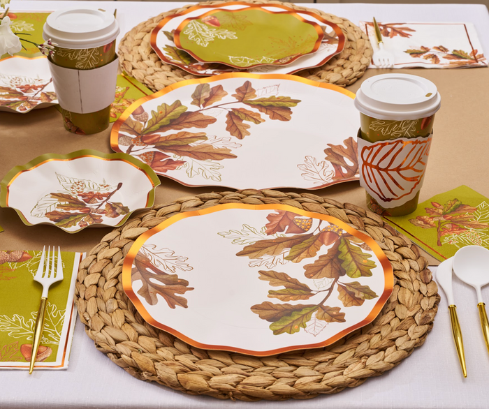 Create a cozy fall tablescape with the Sophistiplate Acorn and Oak Table Setting, featuring autumn-themed disposable plates, woven placemats, plastic cutlery, and hot beverage cups perfect for Thanksgiving gatherings.