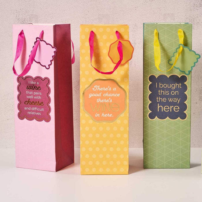 The Bought This- Wine Bag by Drinks On Me is a reusable, colorful wine gift bag with handles and a funny saying: "I bought this on the way here." Perfect for gifts or hostess presents.