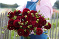 Hand-tied bouquet of deep maroon foxglove (Digitalis) stems with green foliage