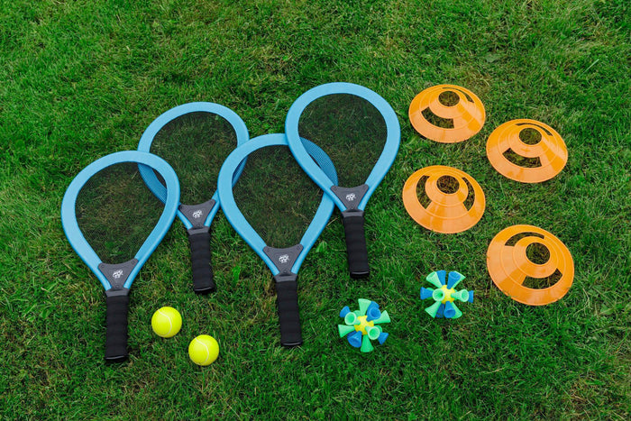 The GO! Play Bash N Bounce Game Set by GO! Play features four blue rackets, two yellow tennis balls, four orange cones, and two green and blue shuttlecocks—ideal for outdoor paddle games on the grass.