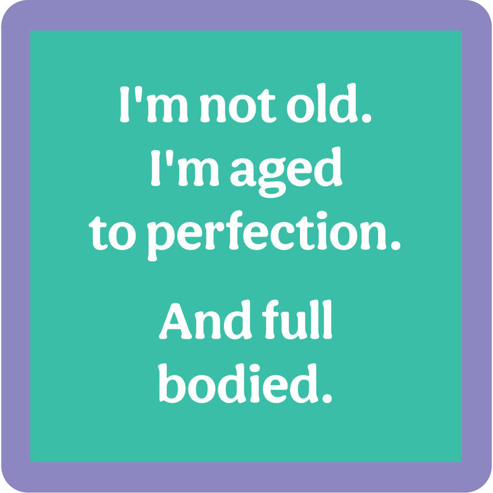 A teal square with rounded corners and a purple border shows white text: I'm not old. I'm aged to perfection. And full bodied—a funny Drinks On Me coaster from the Coaster Bundle: Birthday, perfect as a gift or for your collection.