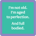 A teal square with rounded corners and a purple border shows white text: I'm not old. I'm aged to perfection. And full bodied—a funny Drinks On Me coaster from the Coaster Bundle: Birthday, perfect as a gift or for your collection.