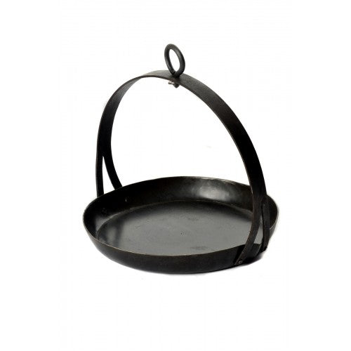 Cast iron tripod skillet hanging from adjustable tripod over garden firepit for outdoor cooking