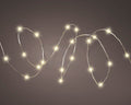 Warm white solar twinkle fairy string lights draped over garden fence at night