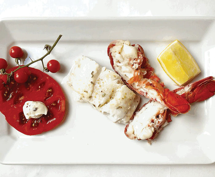A rectangular plate features seafood and veggies, beautifully seasoned with the Bella Cucina Savory Salt Duo Gift Set for enhanced flavor.